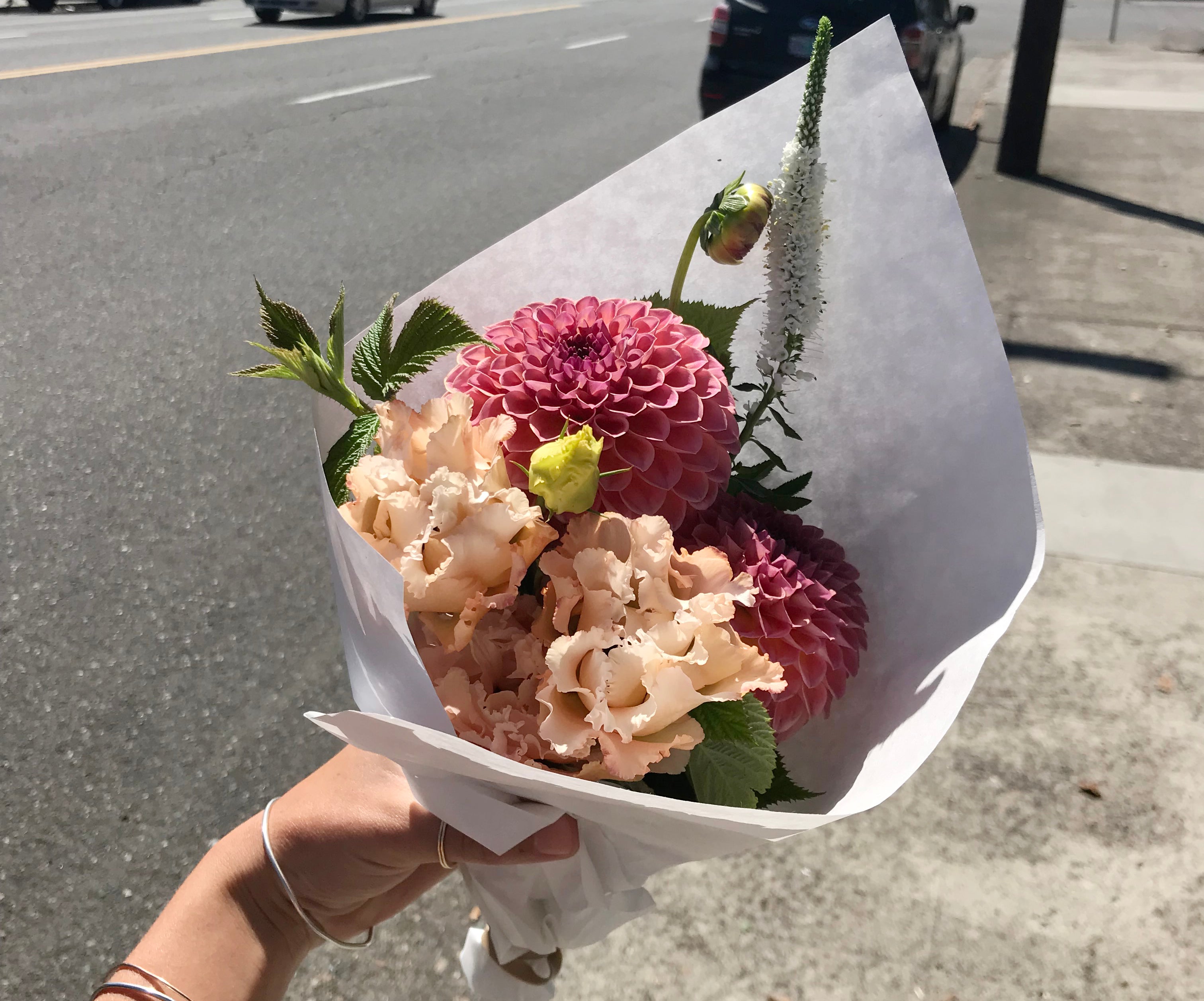 Bouquet of flowers held by a person on a street