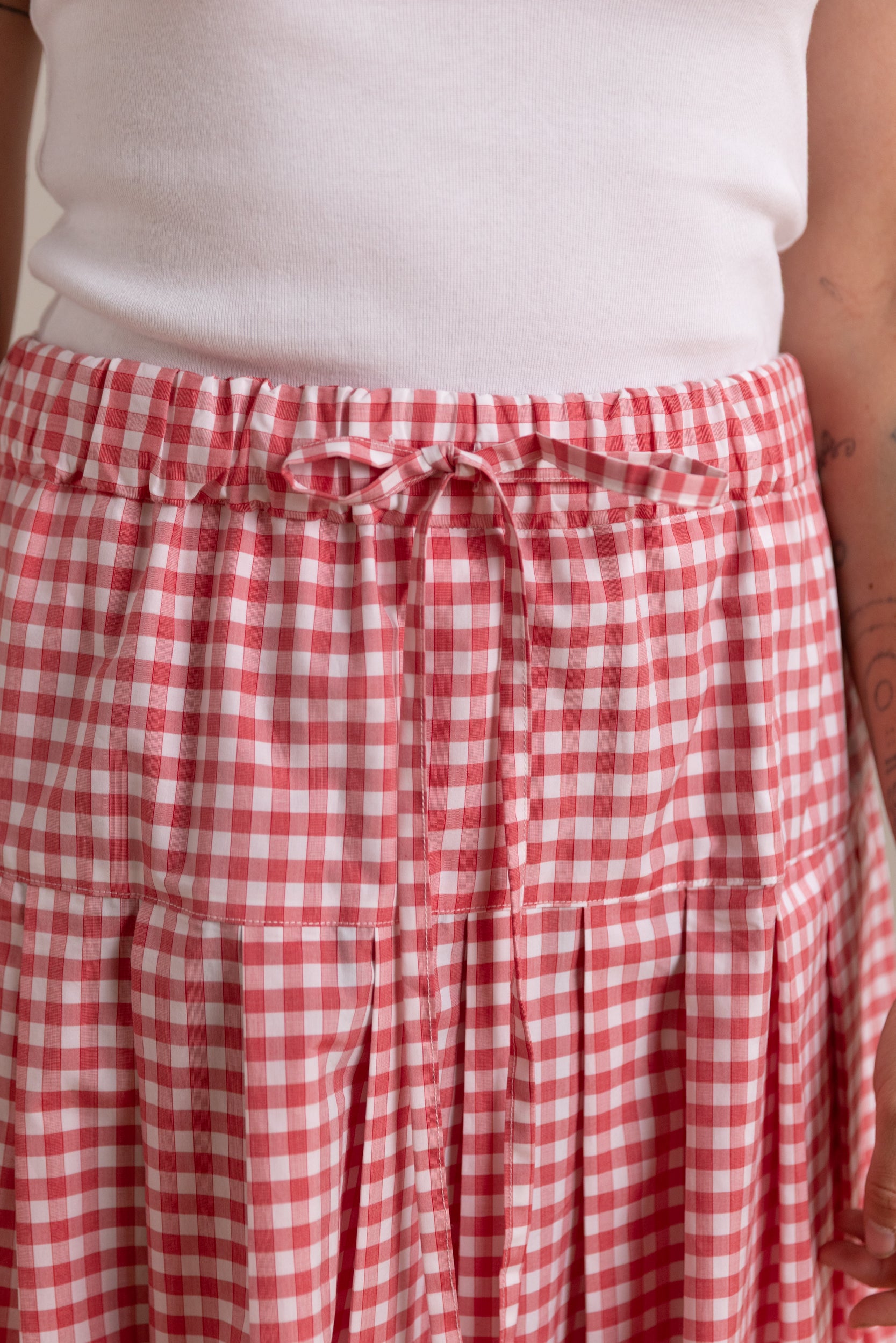 PLEATED SKIRT WITH SIDE SEAM POCKETS IN RED GINGHAM